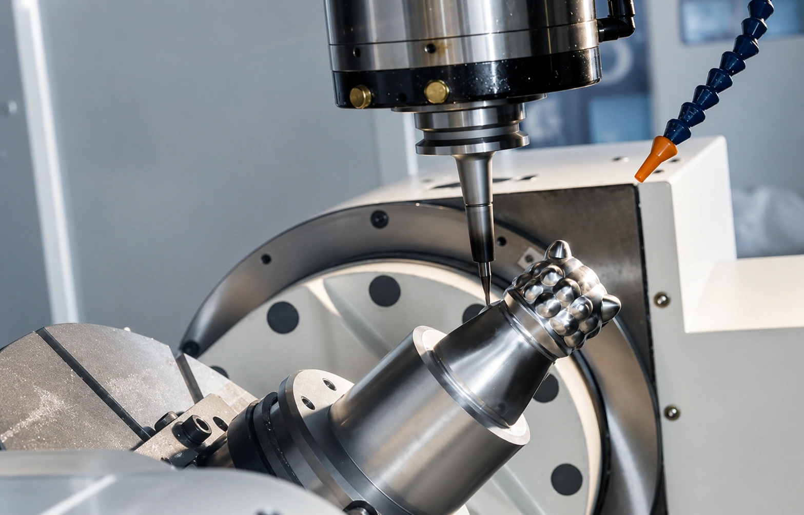 Close-up of a 5-axis CNC machine milling a complex high-precision metal component inside an advanced machining center