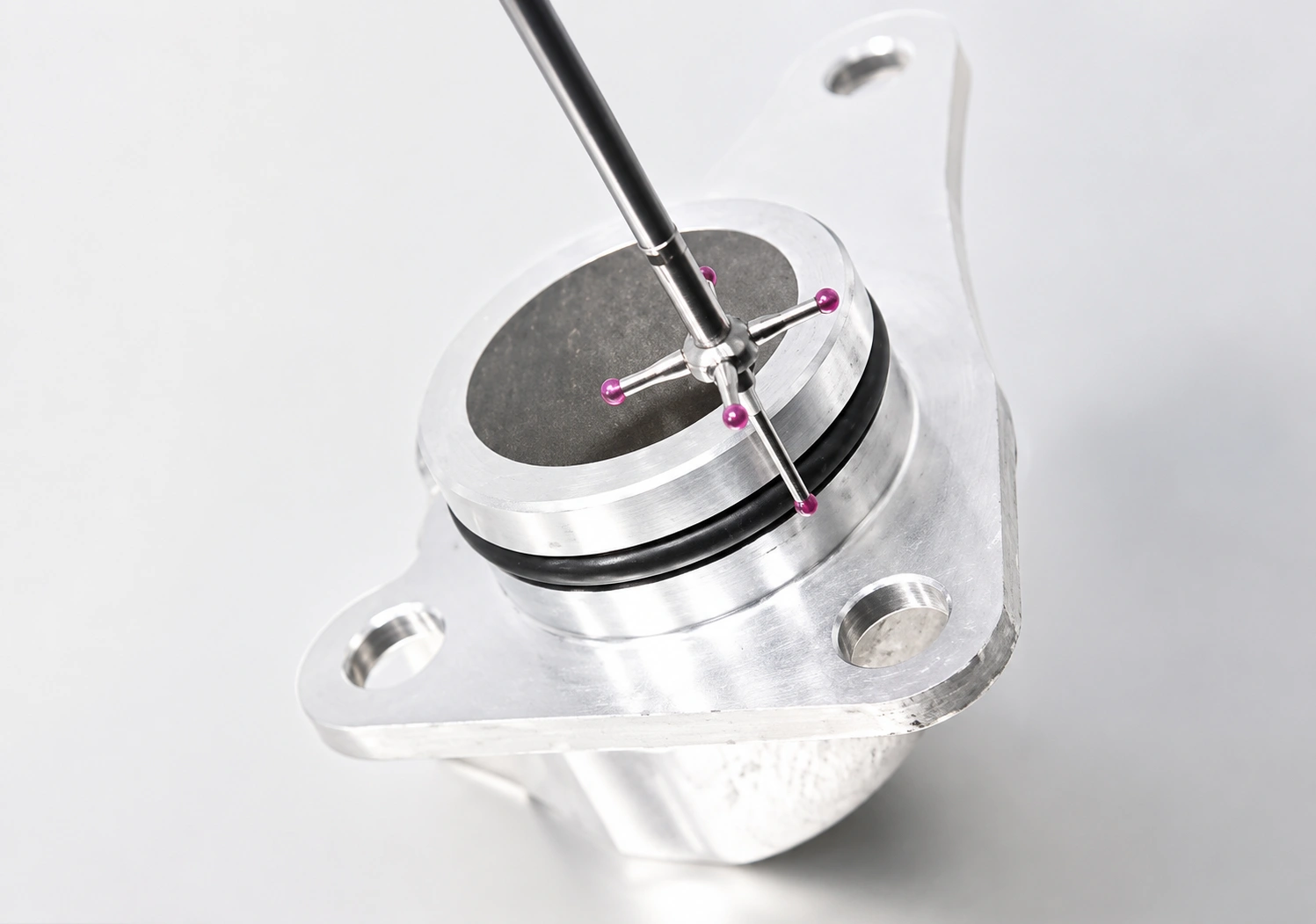 CMM touch probe inspecting a precision-machined metal component for dimensional accuracy and manufacturing quality control.