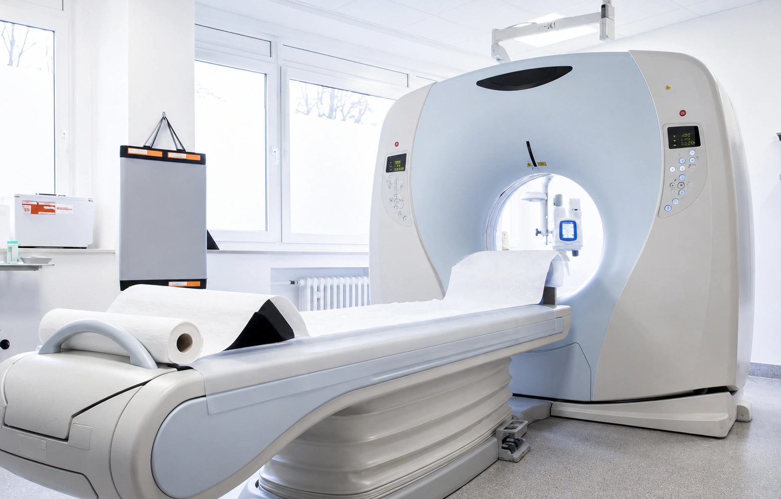 High-resolution view of a modern medical CT scanner and patient table inside a clean diagnostic imaging room
